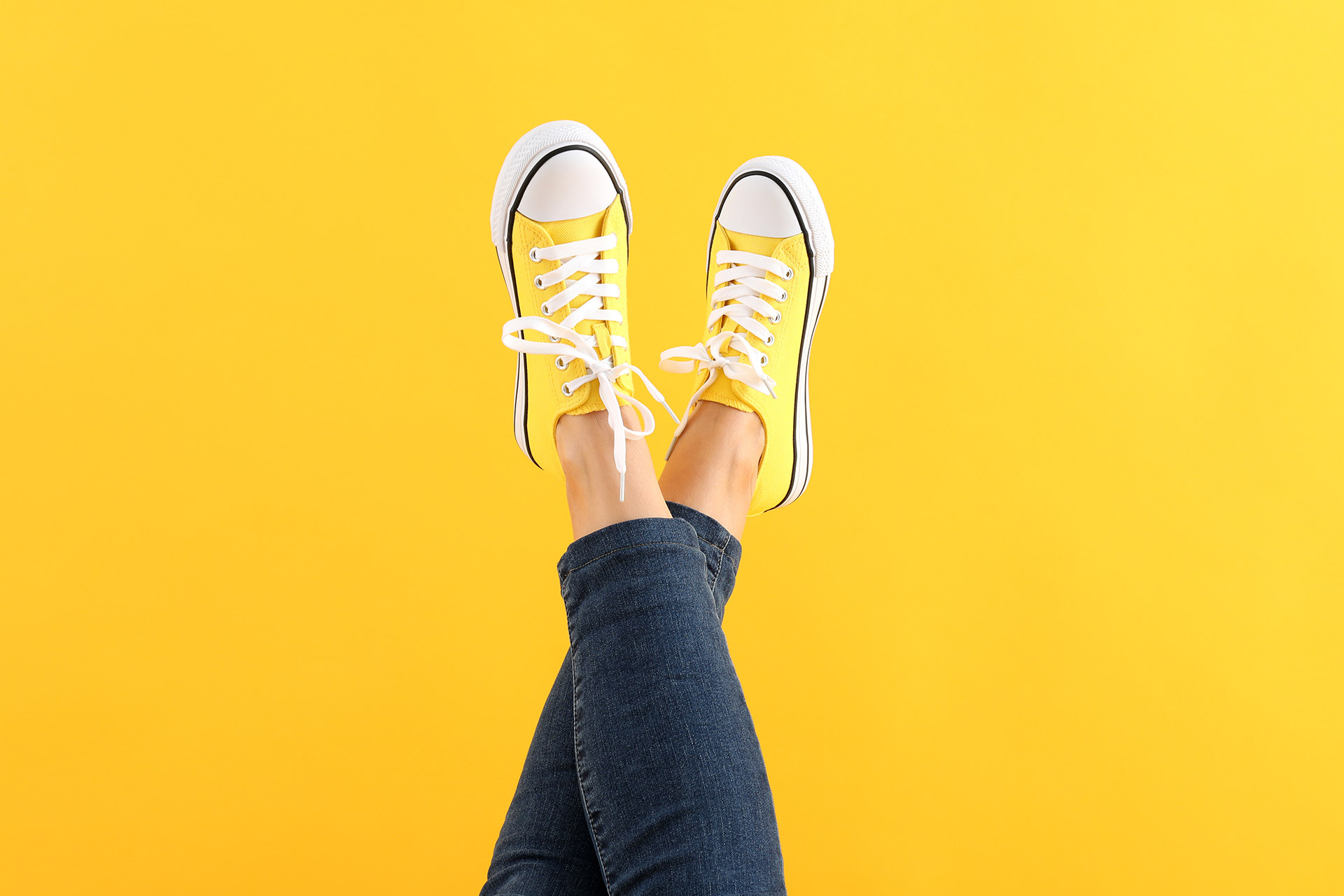 female-legs-in-jeans-and-sneakers-on-yellow-backgr-2022-01-30-07-07-58-utc.jpg